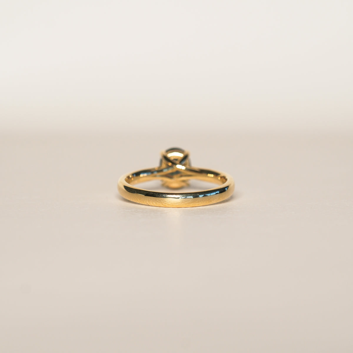 1.2 carat teal blue parti sapphire engagement ring with hidden halo in 18ct yellow gold. Cathedral settings 