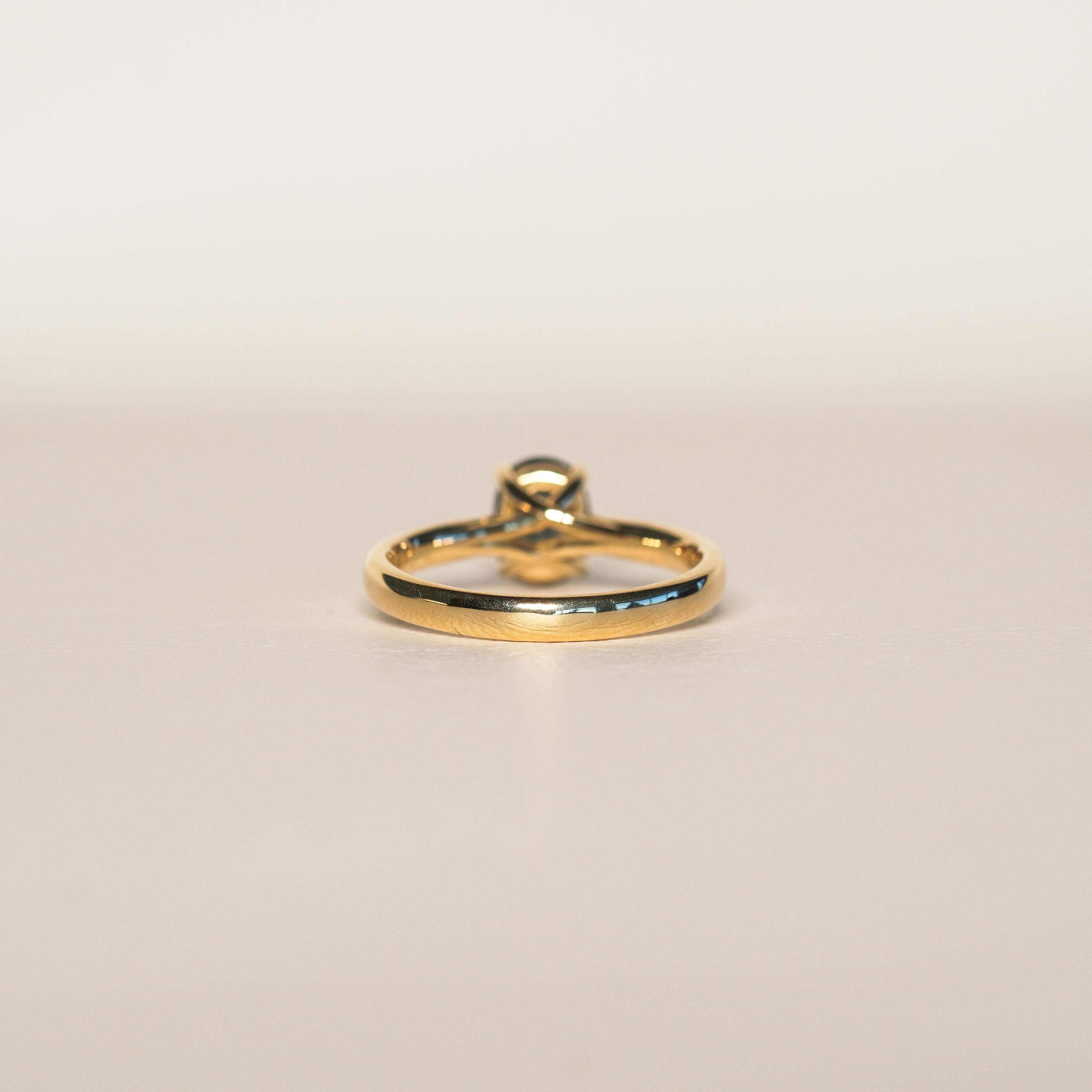 1.2 carat teal blue parti sapphire engagement ring with hidden halo in 18ct yellow gold. Cathedral settings 