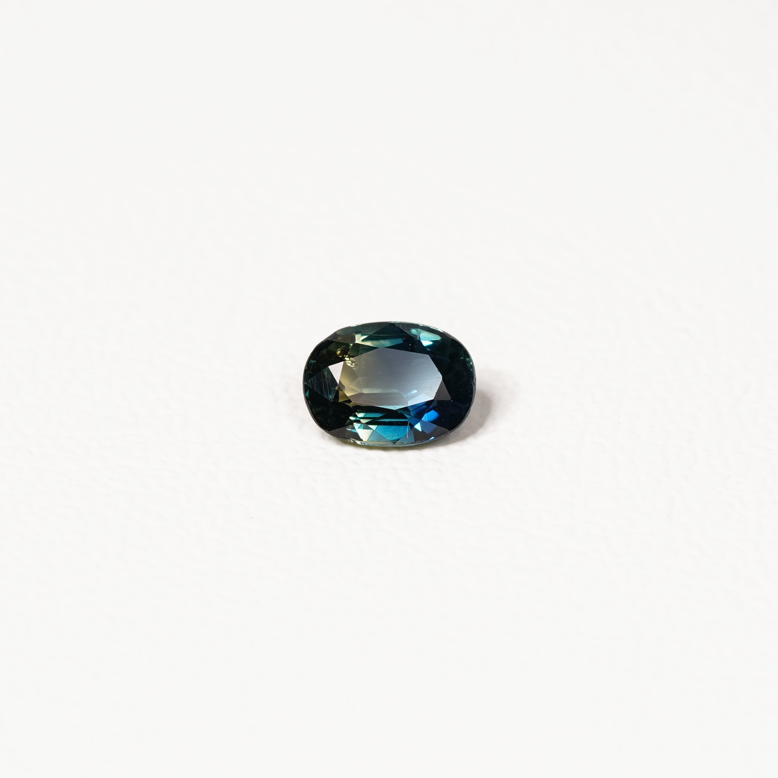  1.25ct Australian parti sapphire oval — deep teal with copper flash through table, face-up — Ruhuna Gemstones