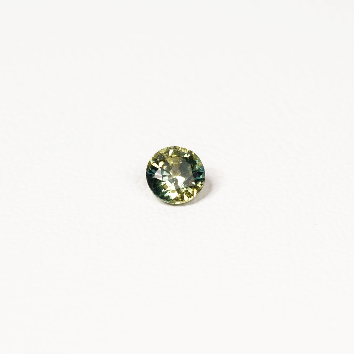 0.90ct Australian parti sapphire round — bright yellow-green body with teal crown accent, face-up — Ruhuna Gemstones