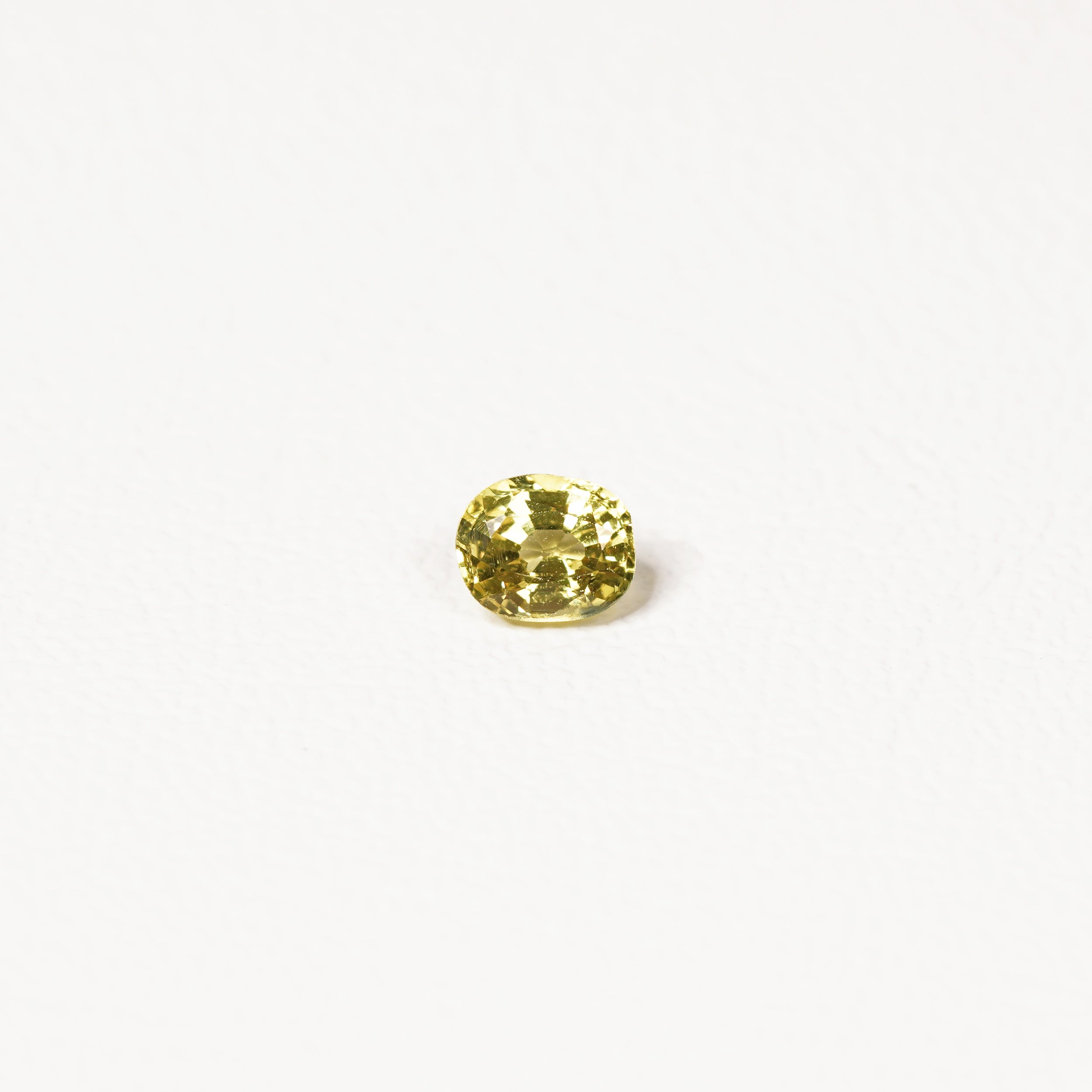 0.85ct Australian yellow-green sapphire cushion — soft pale chartreuse colour, face-up view — Ruhuna Gemstones