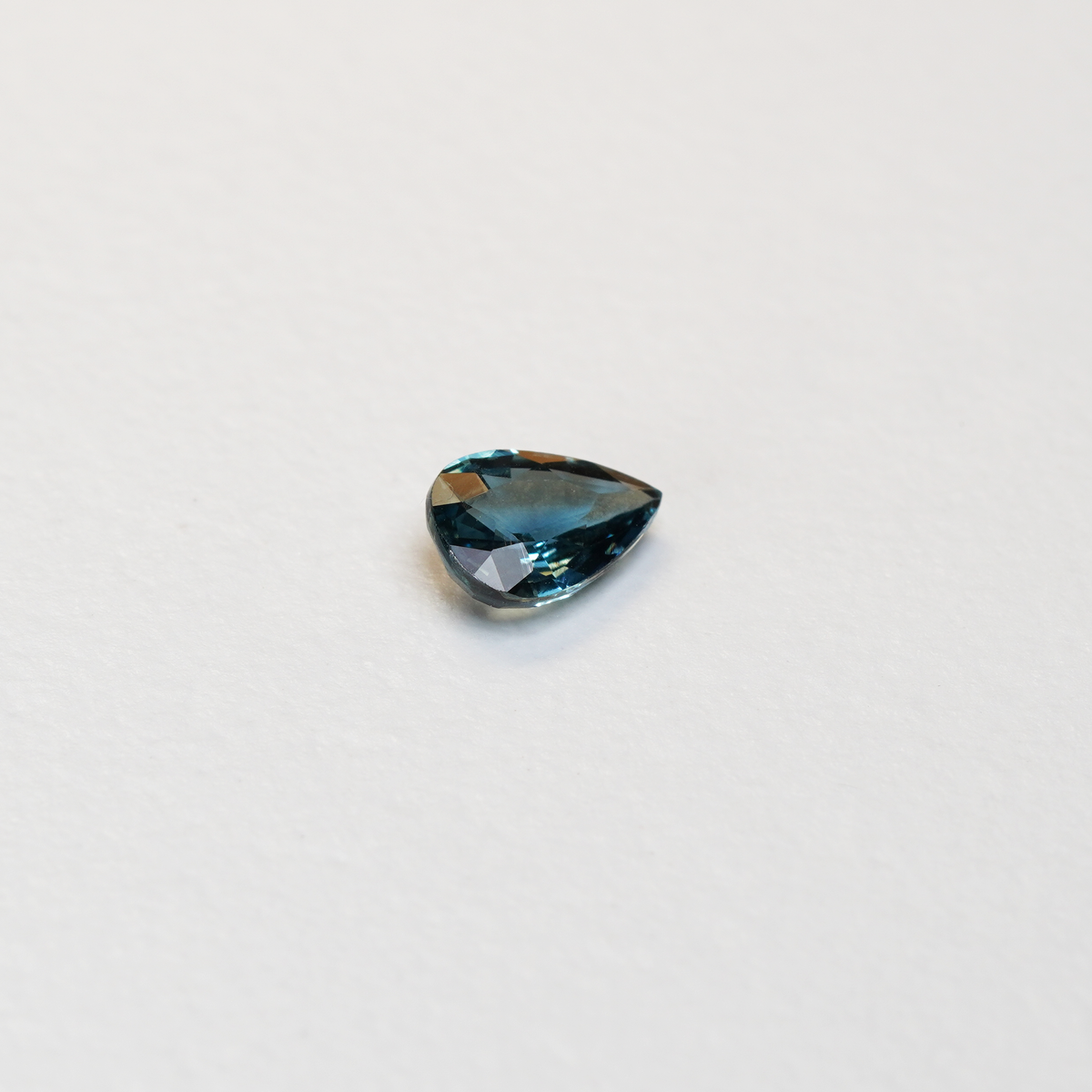 1 carat pear parti teal sapphire with mixed green and blue color.