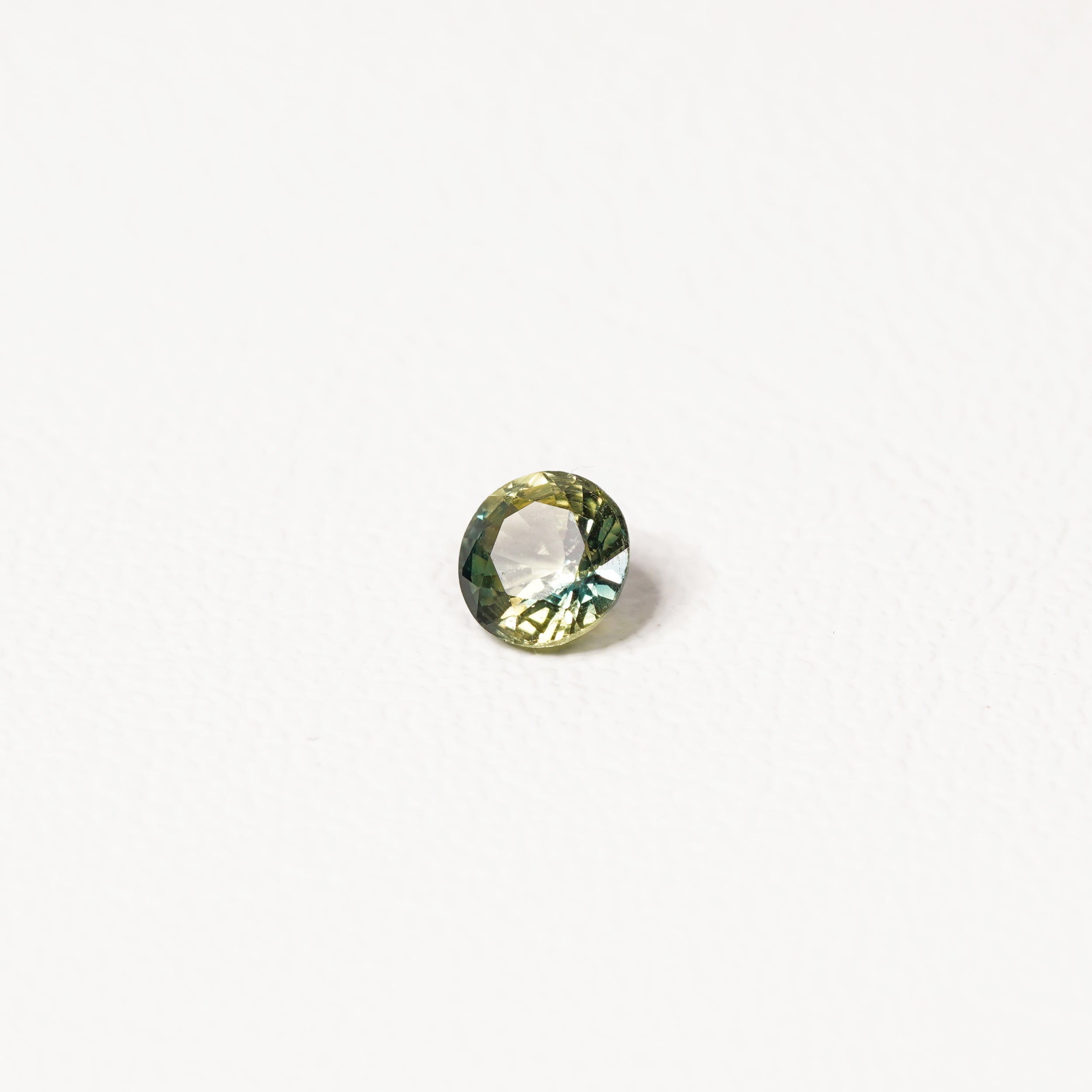 0.90ct Australian parti sapphire round — bright yellow-green body with teal crown accent, face-up — Ruhuna Gemstones