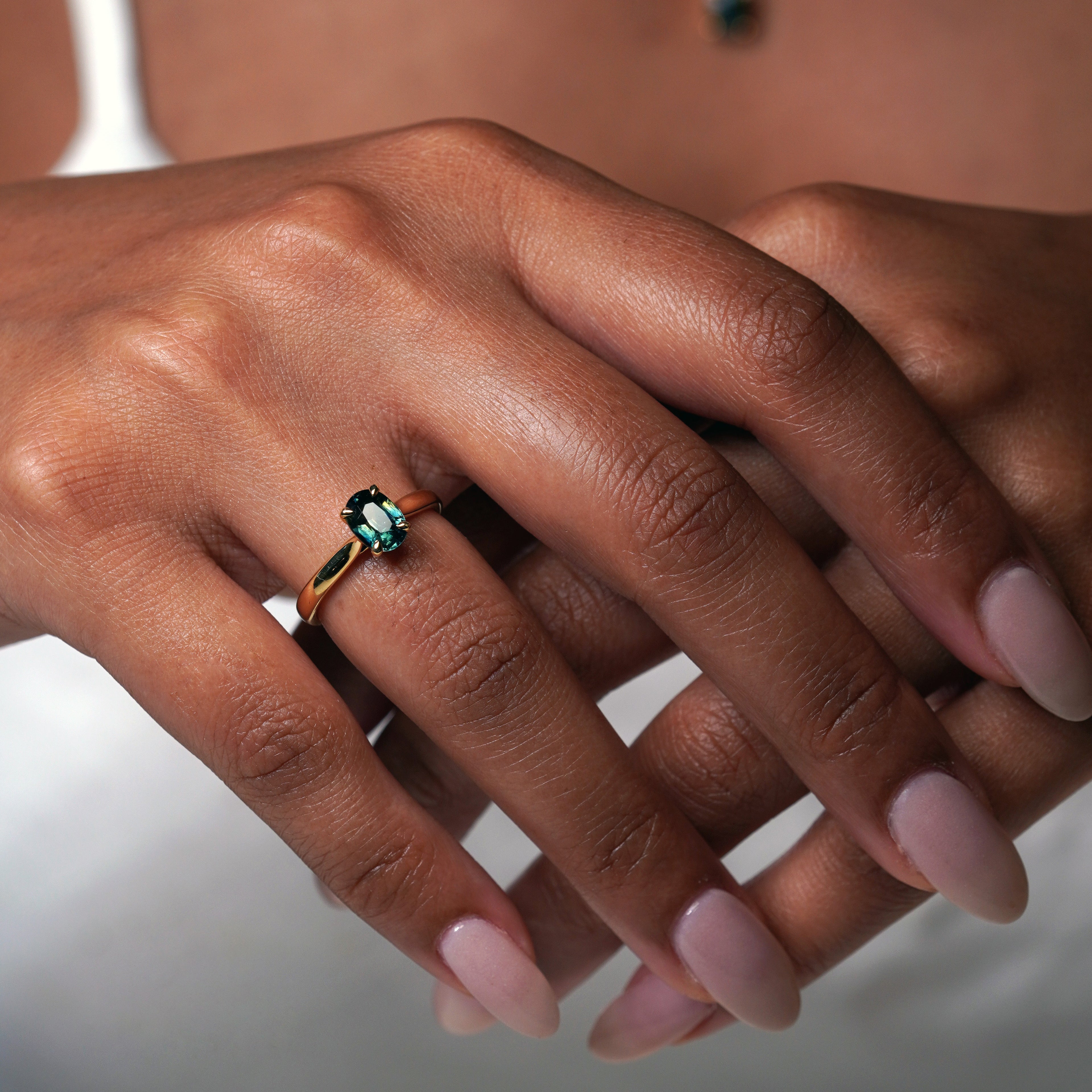 1.2 carat teal blue parti sapphire engagement ring with hidden halo in 18ct yellow gold. Cathedral settings 