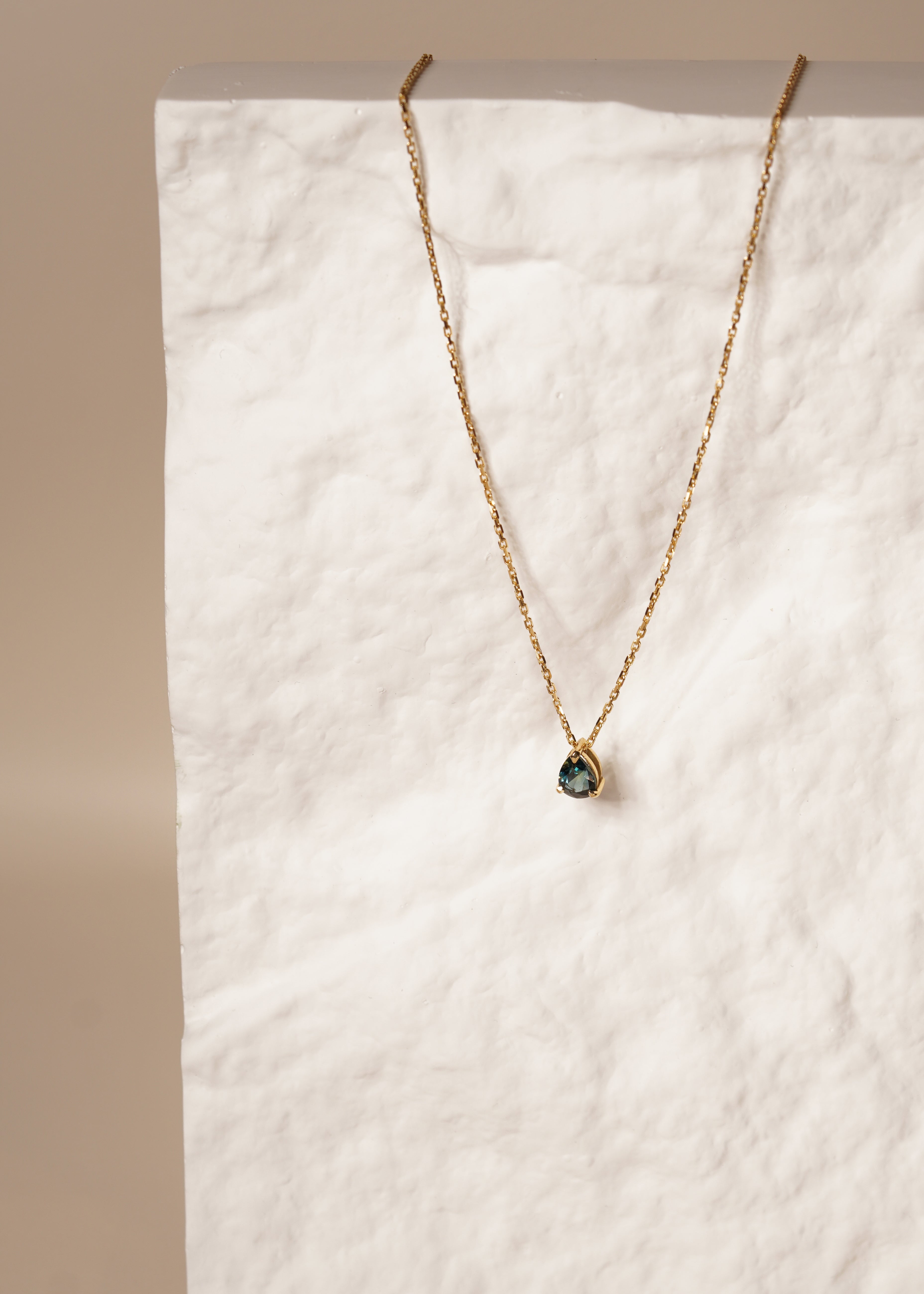 1.2 carat pear teal parti sapphire hidden bail necklace with double gallery basket in 18ct yellow gold
