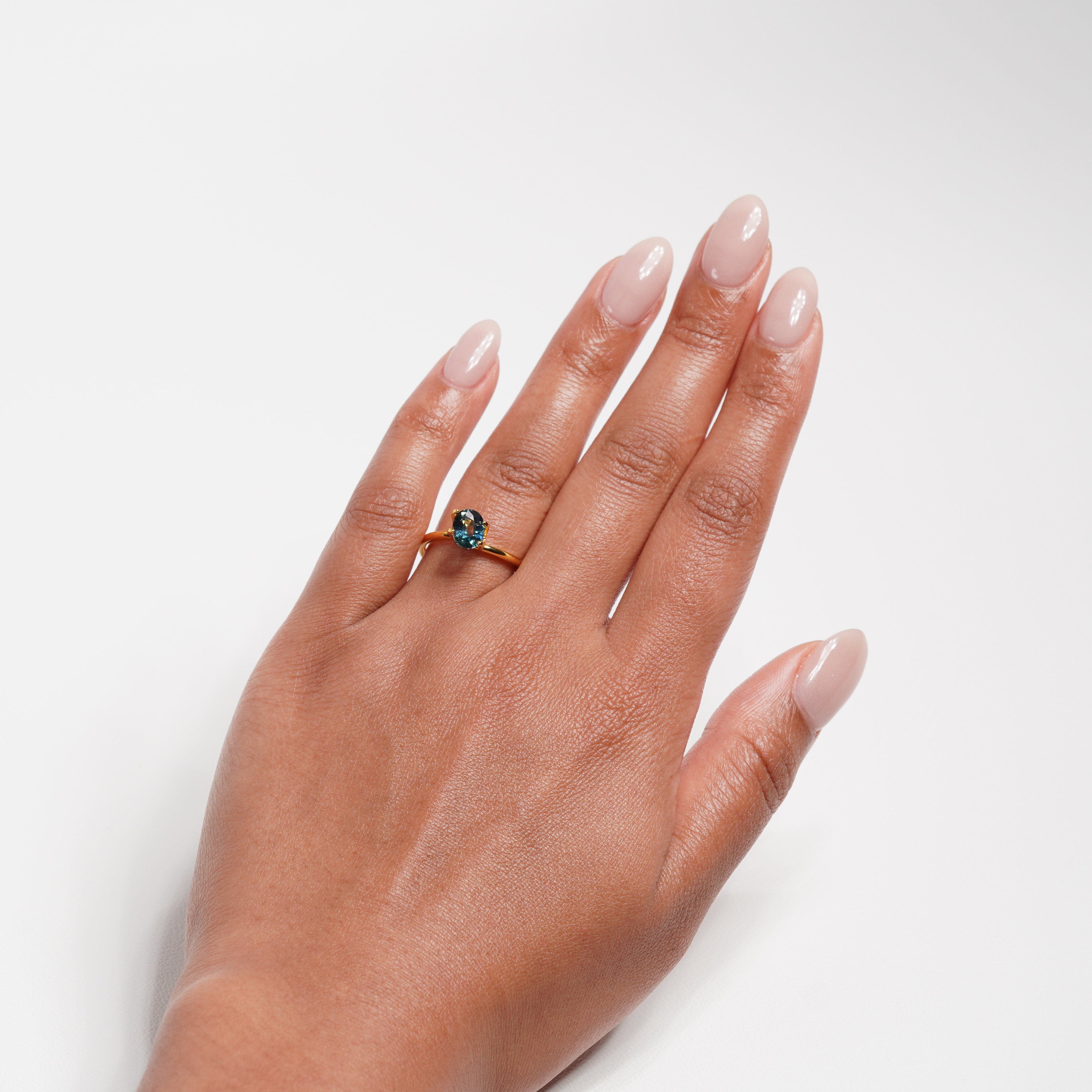 1.25 carat oval parti teal sapphire ring with mixed green and blue color.