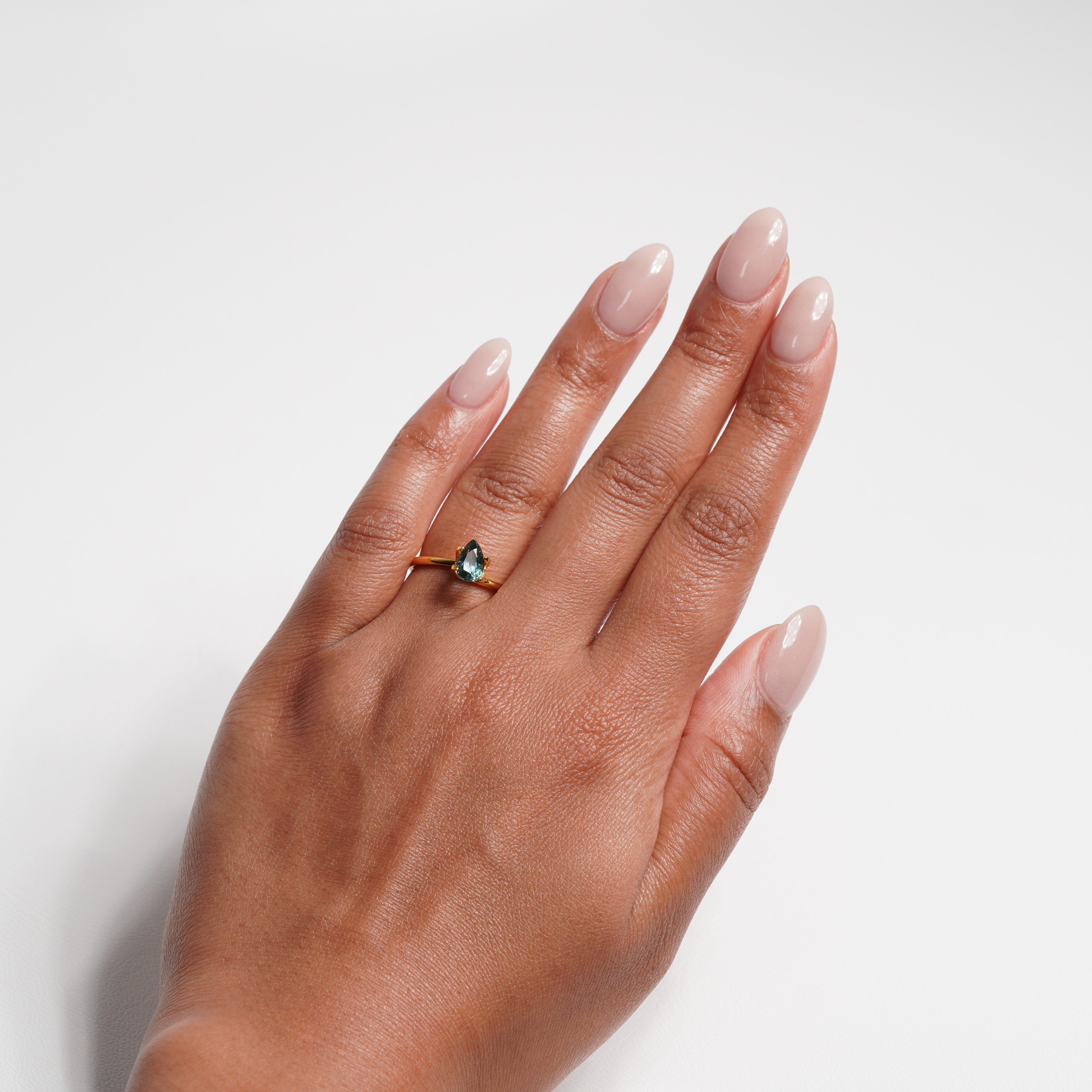 1.1 carat pear parti teal sapphire ring with mixed green and blue color.