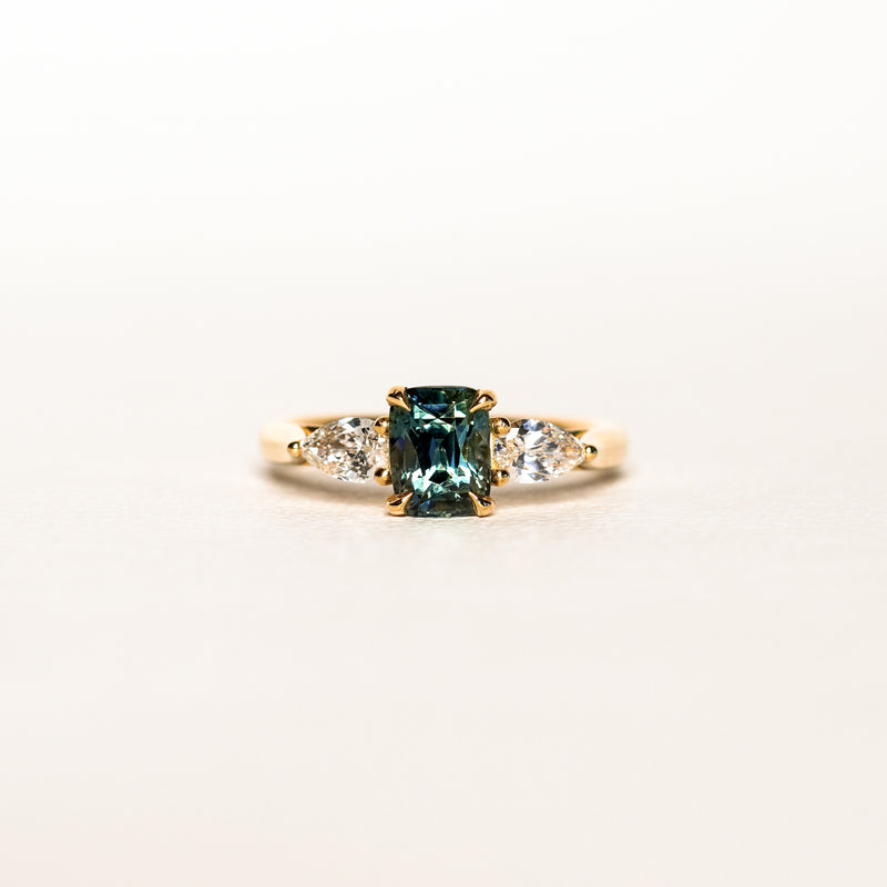 1.55 carat teal parti sapphire engagement ring with pair cut diamonds in 18ct yellow gold