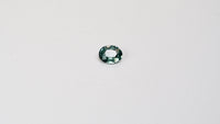 1.10 carat oval parti teal sapphire with mixed green and blue color.