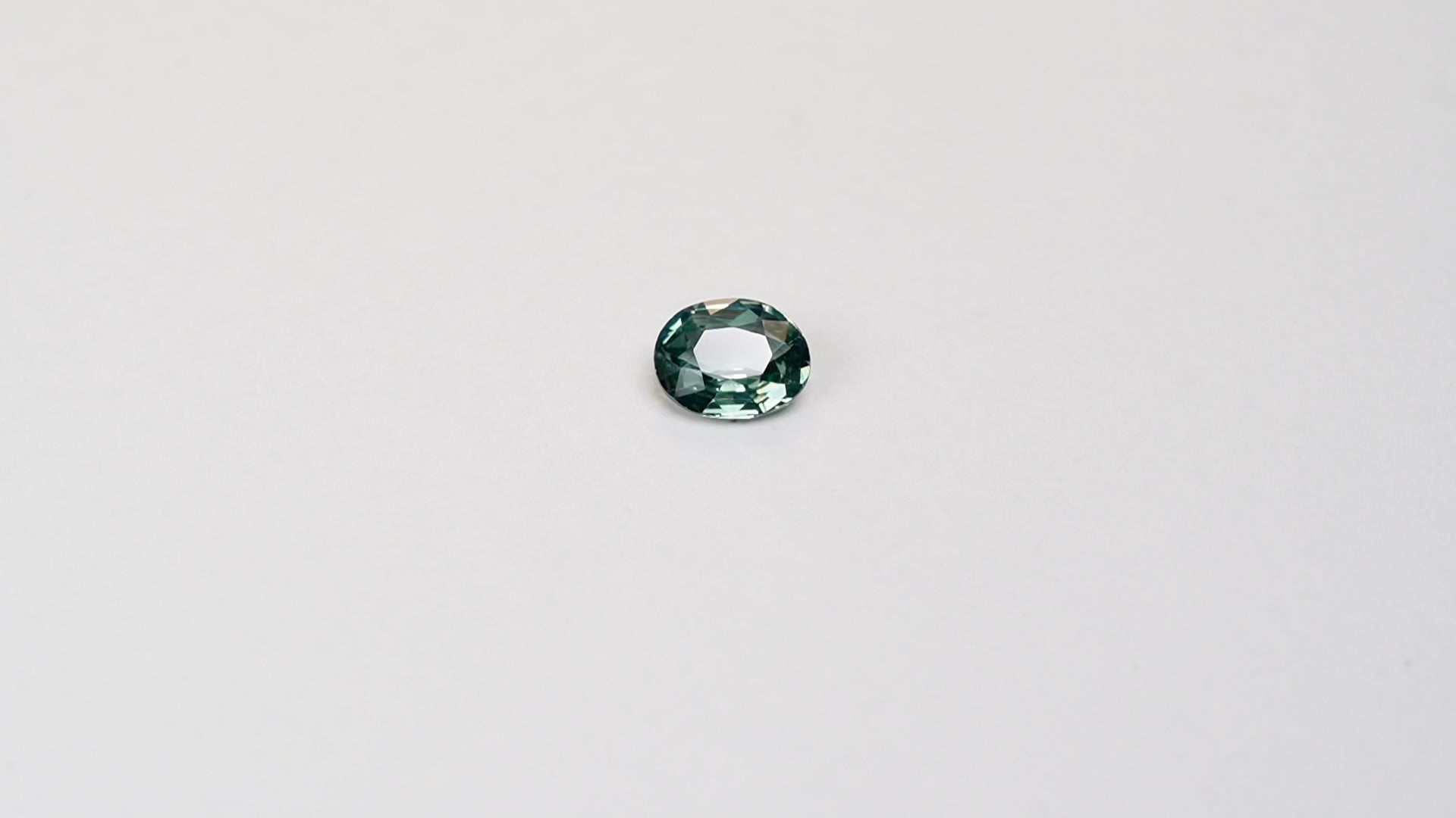 1.10 carat oval parti teal sapphire with mixed green and blue color.