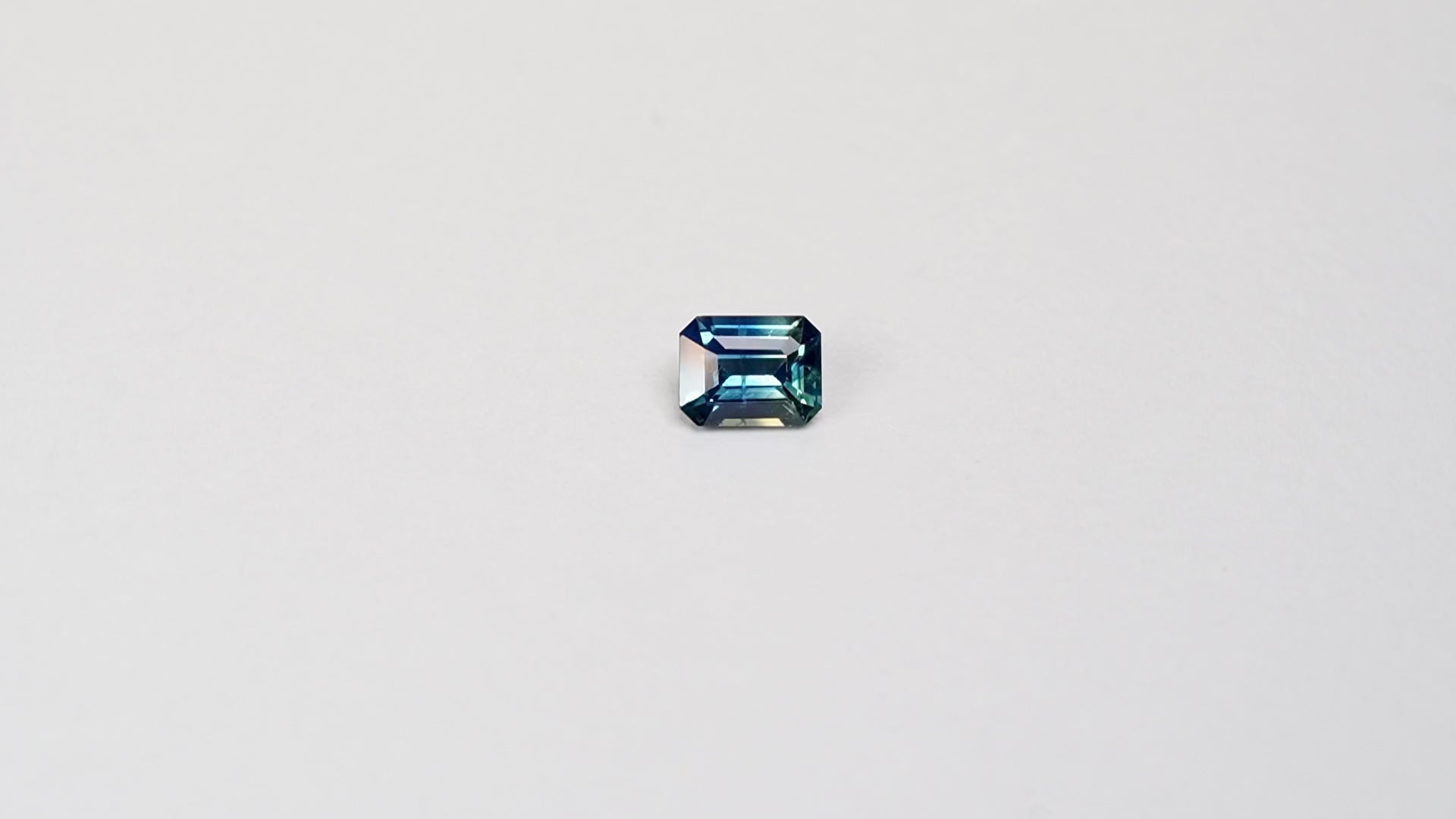 1.1 carat cushion cut parti teal sapphire with mixed green and blue color.