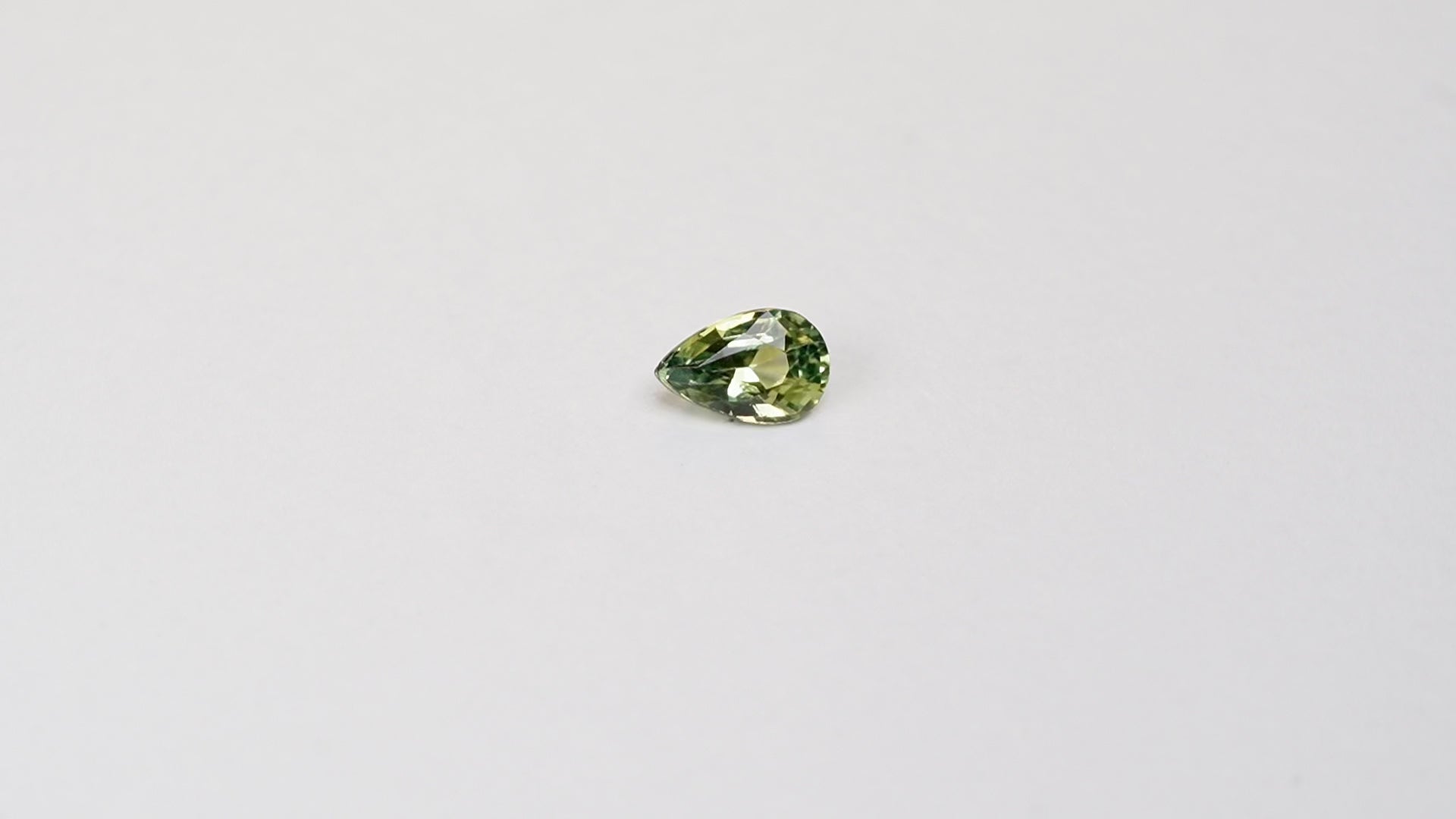 1 carat pear parti teal sapphire with mixed green and yellow color.