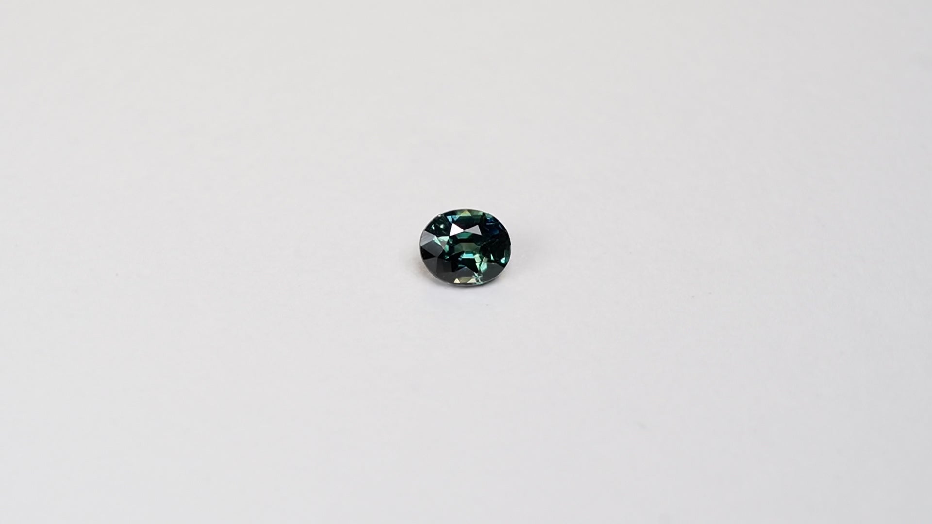 1.1 carat oval parti teal sapphire with mixed green and blue color.