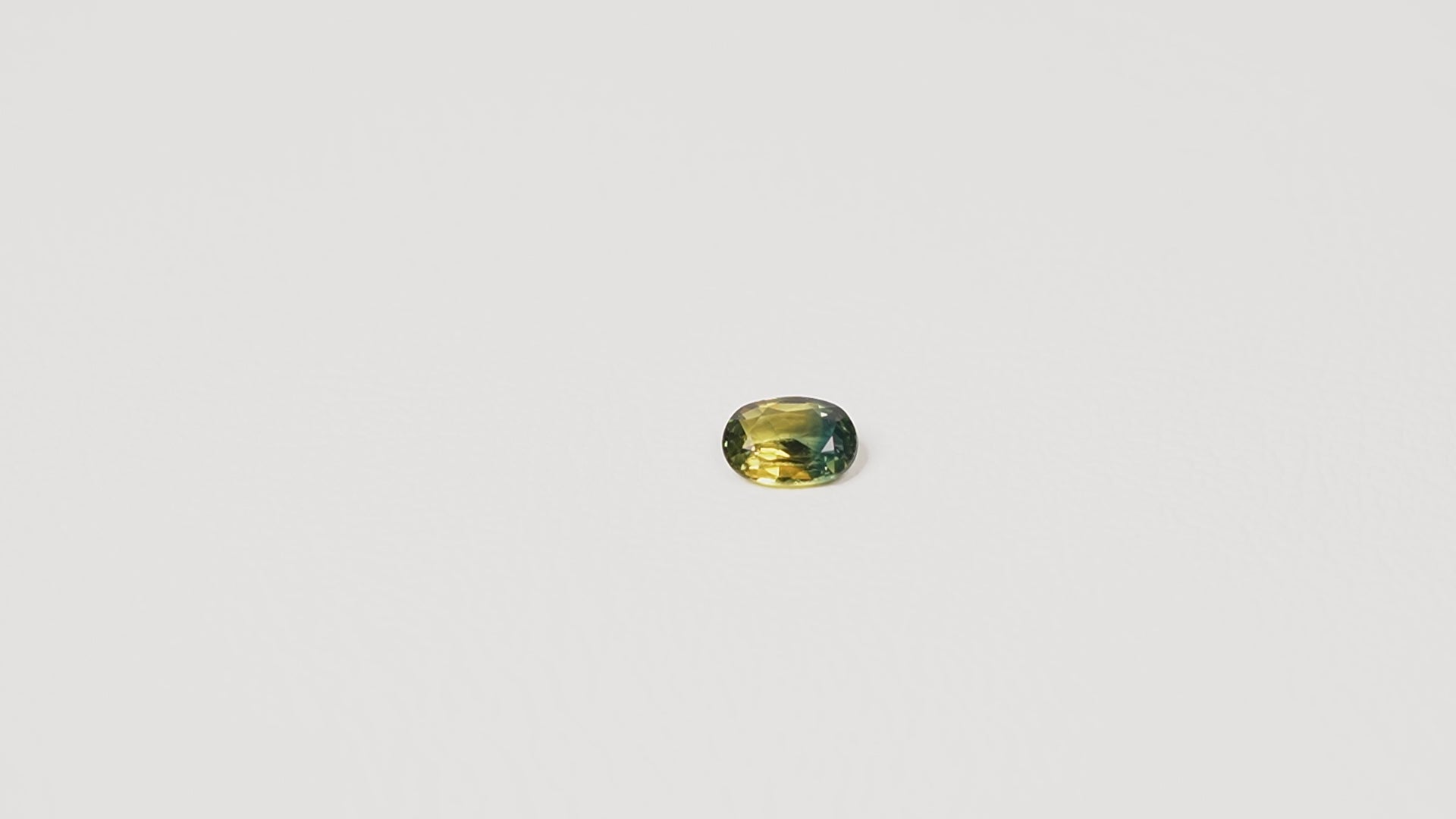 0.90ct Australian parti sapphire oval — golden yellow and teal-green colour zones, face-up — Ruhuna Gemstones