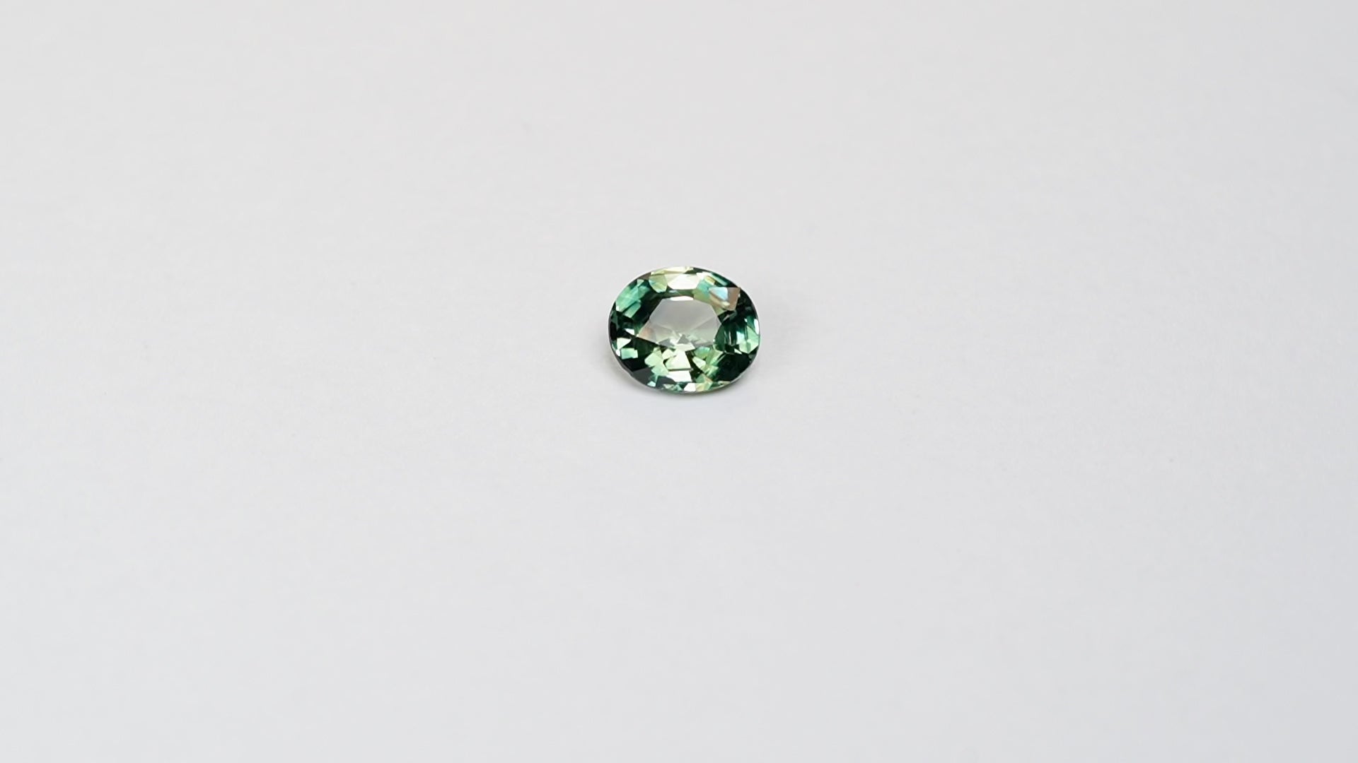 1.3 carat oval parti teal sapphire with mixed green and blue color.