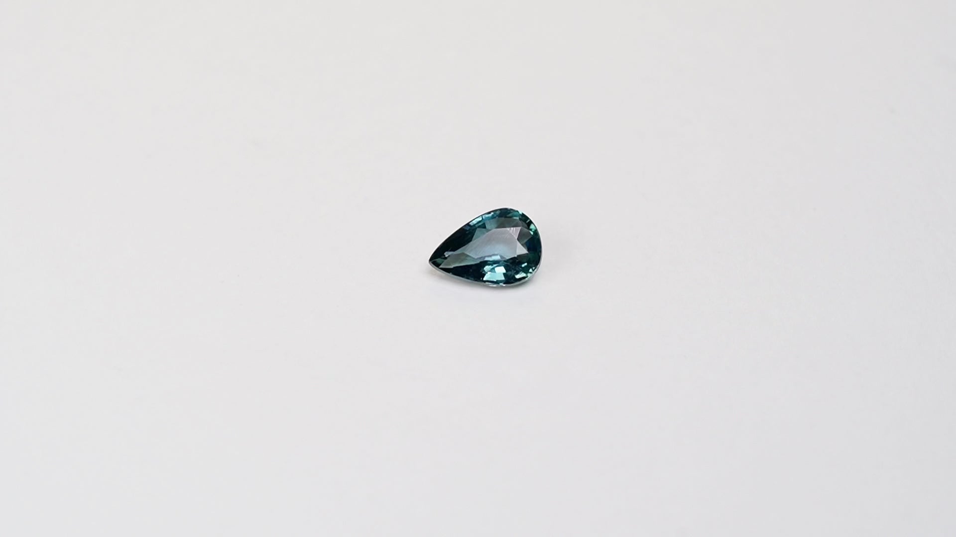 1 carat pear parti teal sapphire with mixed green and blue color.