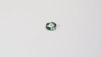 1.10 carat oval parti teal sapphire with mixed green and yellow color.