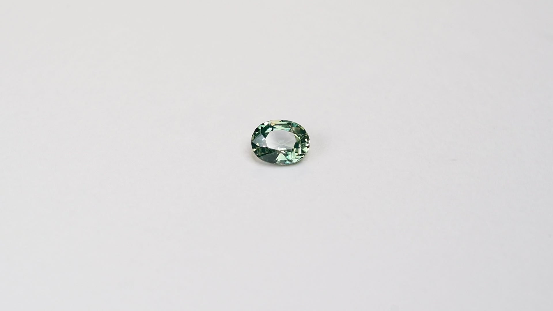 1.10 carat oval parti teal sapphire with mixed green and yellow color.