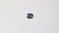 1.25 carat oval parti teal sapphire with mixed green and blue color.