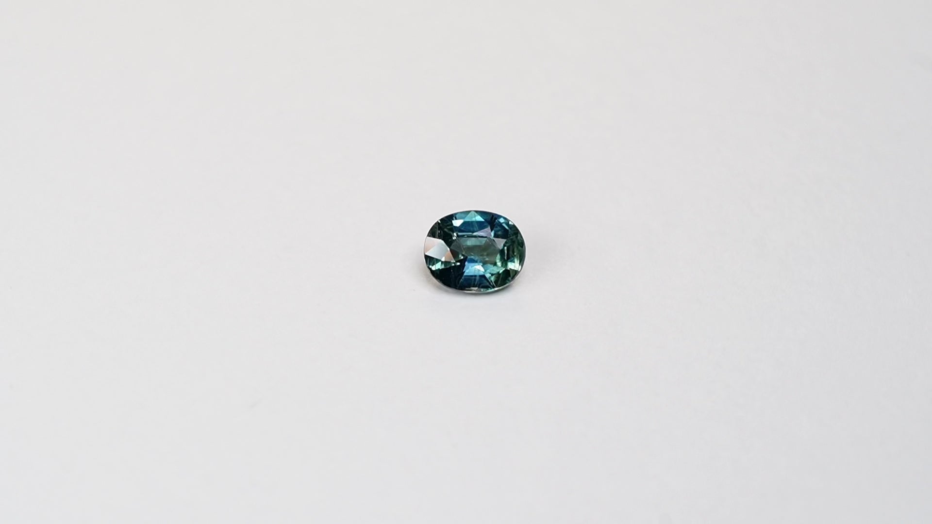 1.25 carat oval parti teal sapphire with mixed green and blue color.